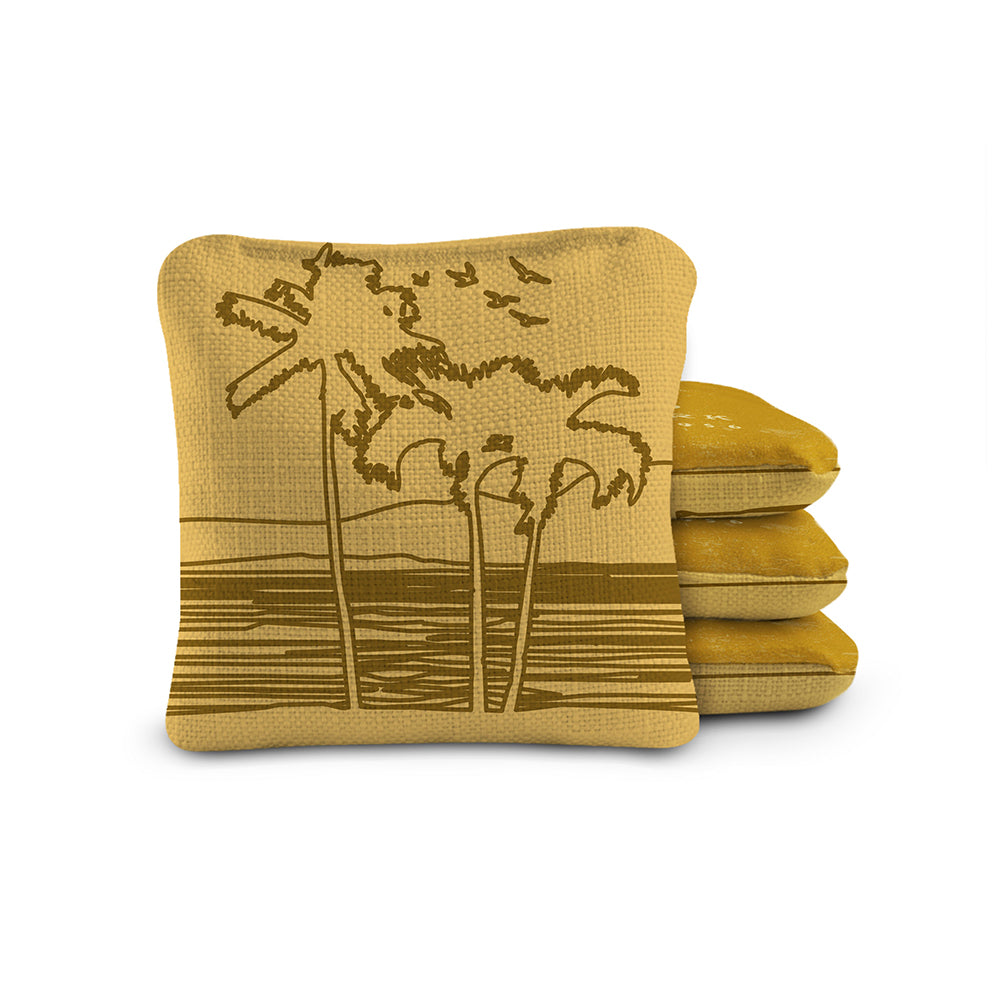 Stack of mustard yellow pillows with palm tree design on a white background