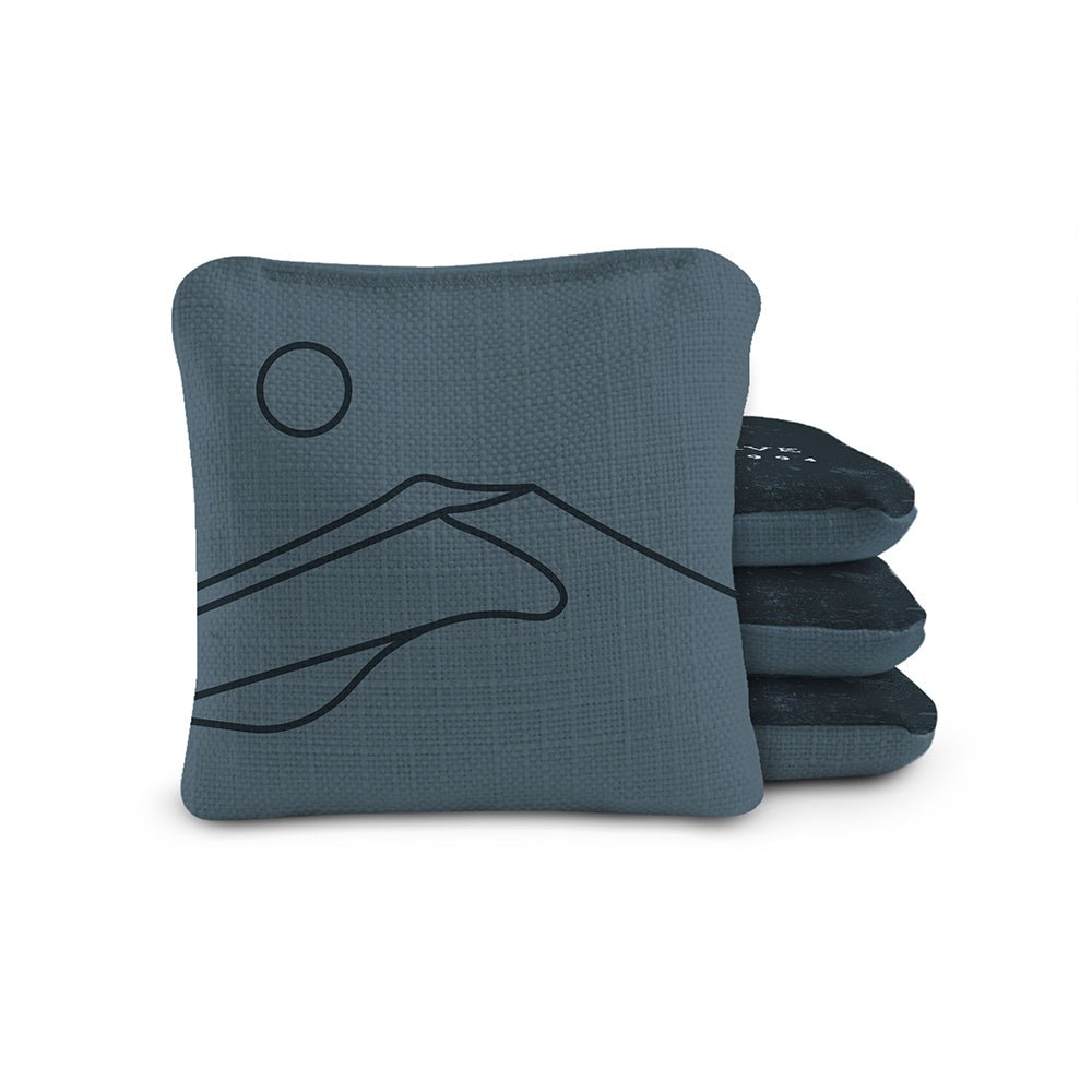 Set of blue cornhole bags with black designs on a white background