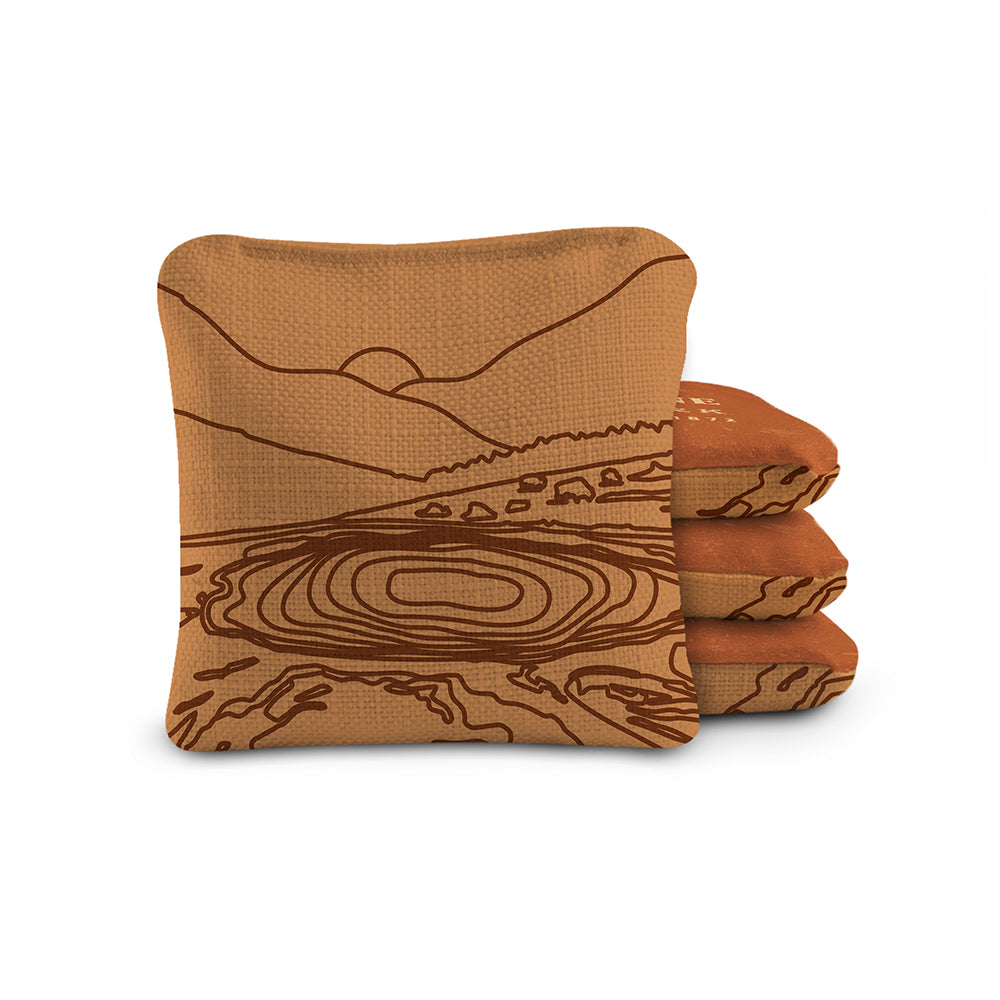Stack of brown towels with a landscape design on a white background