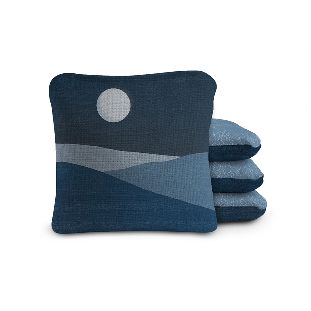 Stack of blue pillows with a moon design on a white background