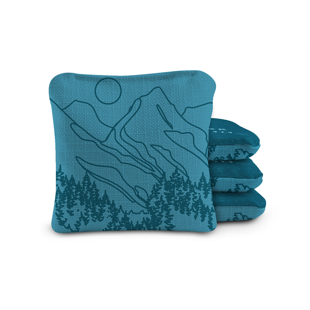 Set of blue bean bags with mountain and tree design on a white background