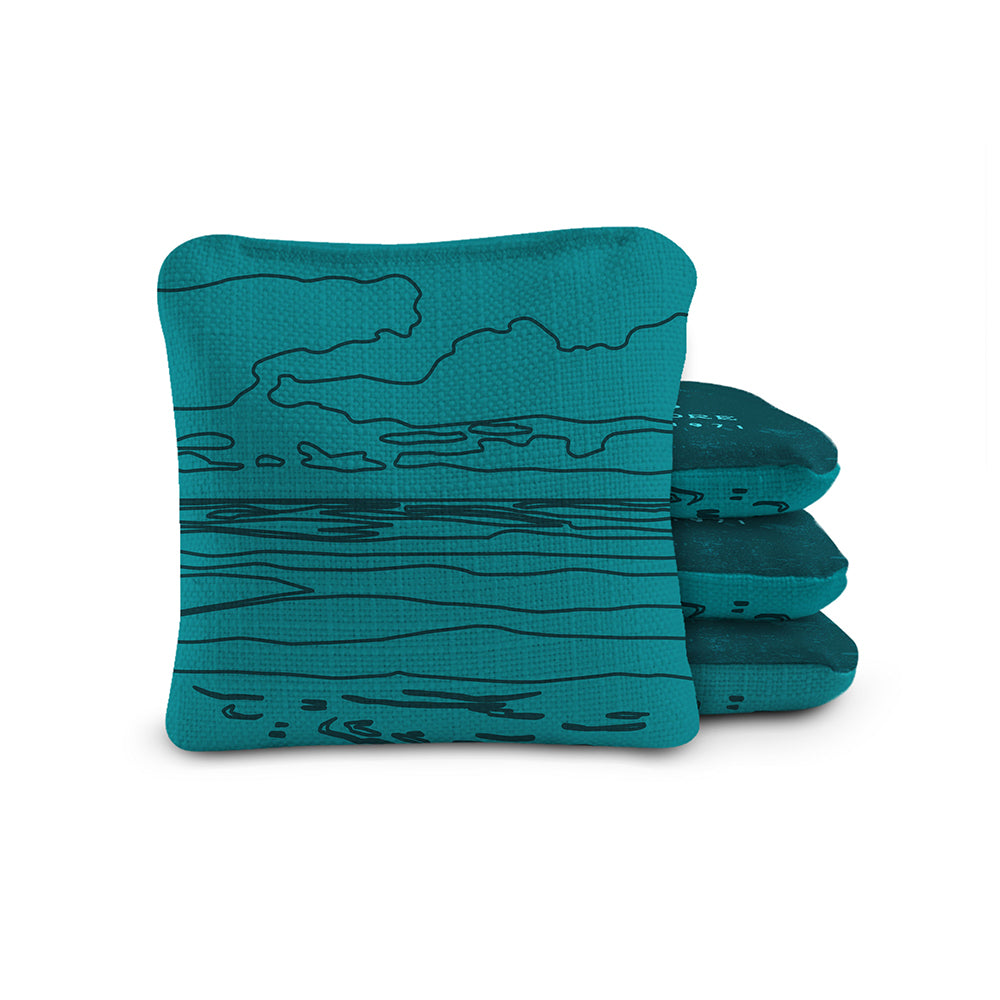 Three teal socks with black line art design on a white background