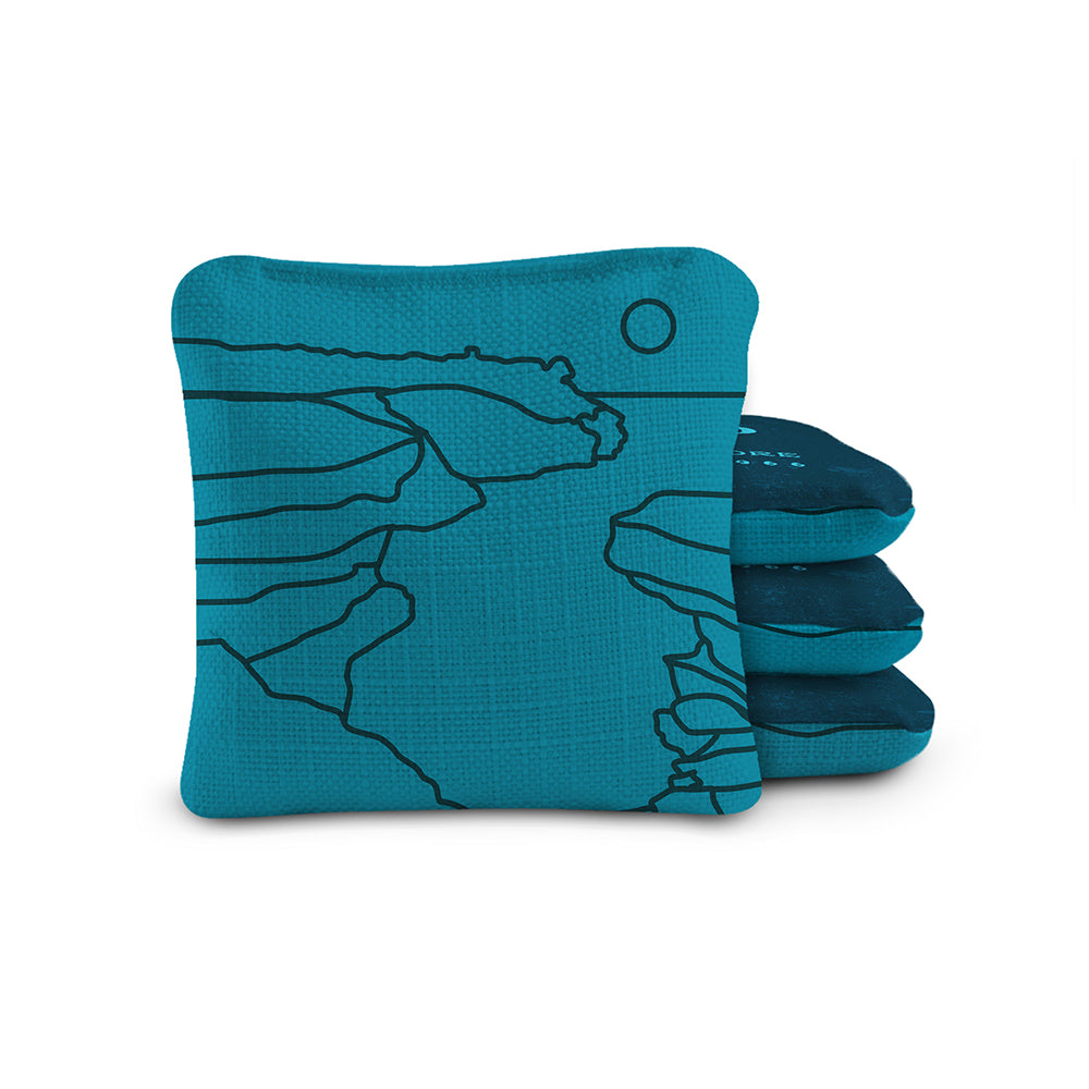 Set of blue cornhole bags with a design on a white background