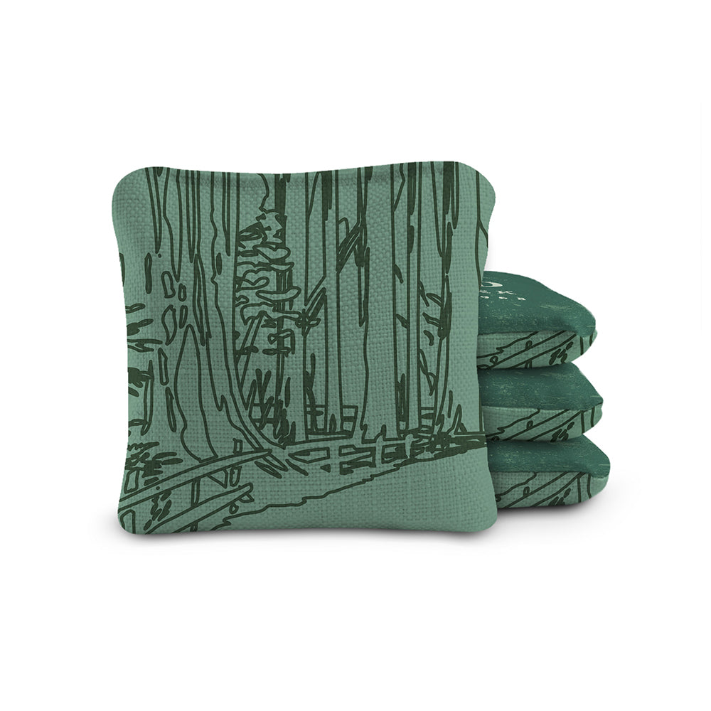 Stack of green fabric coasters with a tree pattern on a white background