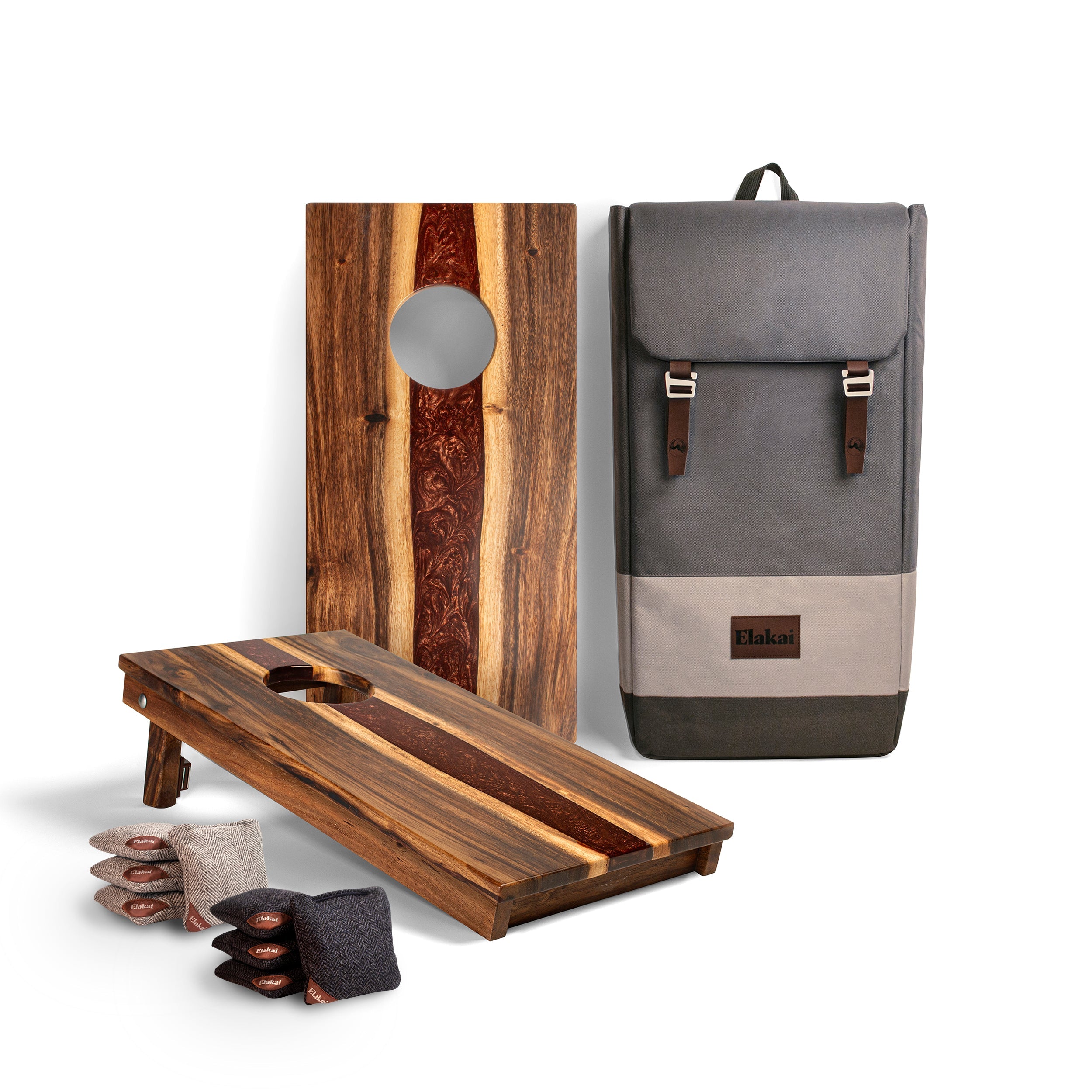 Wooden cornhole boards with bags and a gray backpack on a white background