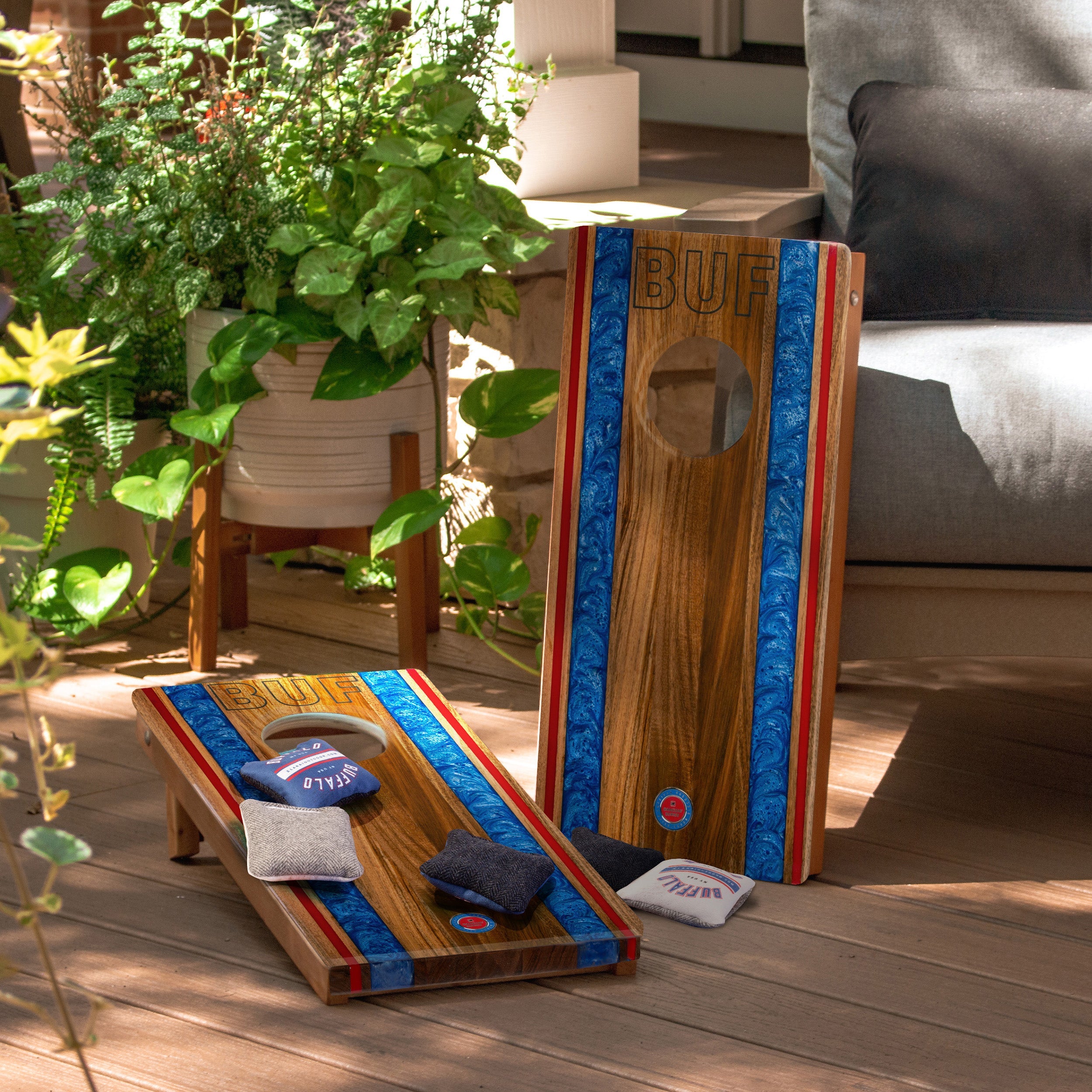 Wooden cornhole boards with colorful designs on a wooden deck.