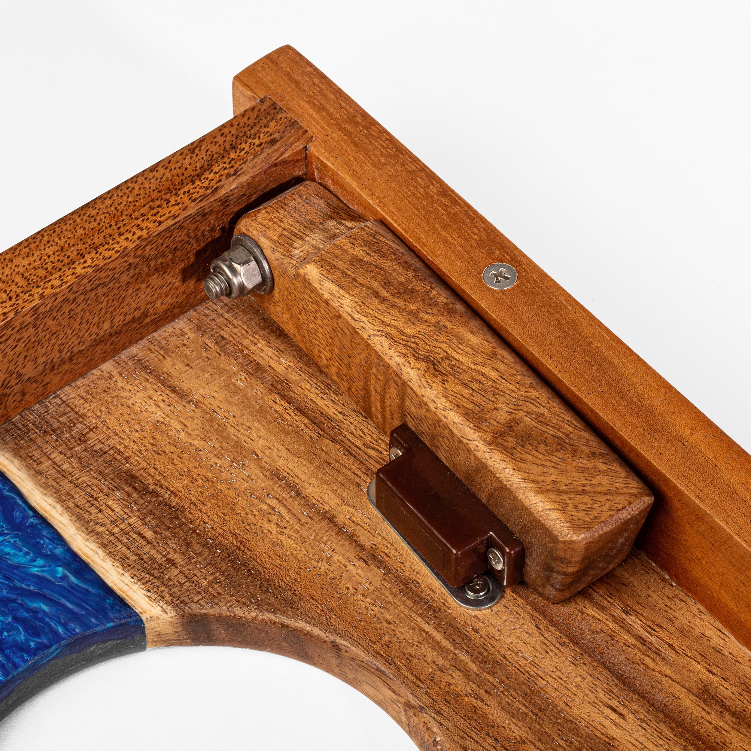 Close-up of a wooden object with blue and metal components on a white background