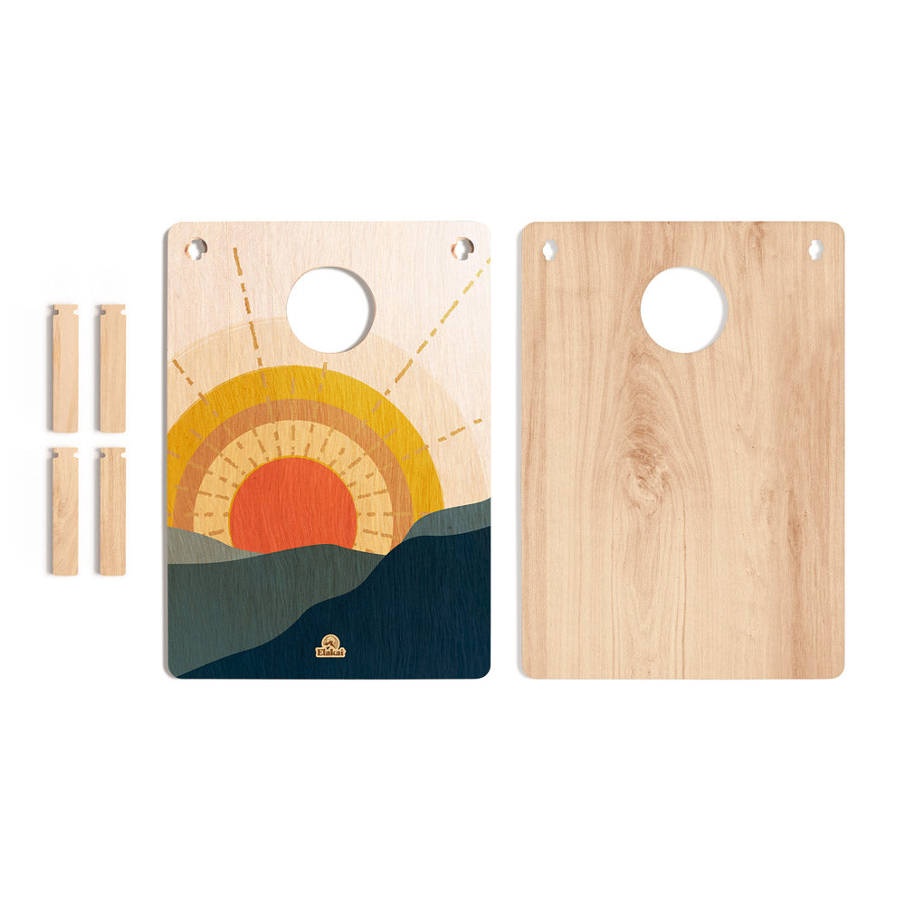 Wooden cutting board with sunset design and additional wooden pieces on a white background