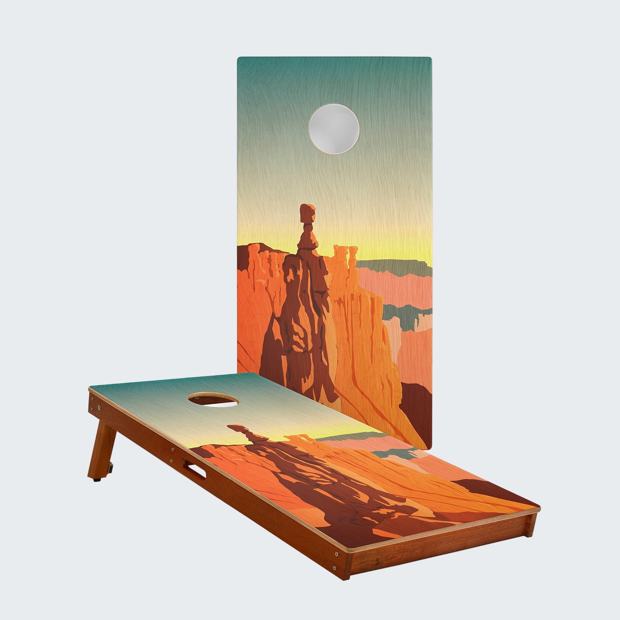 Cornhole board with desert landscape design featuring a silhouette of a person on horseback.