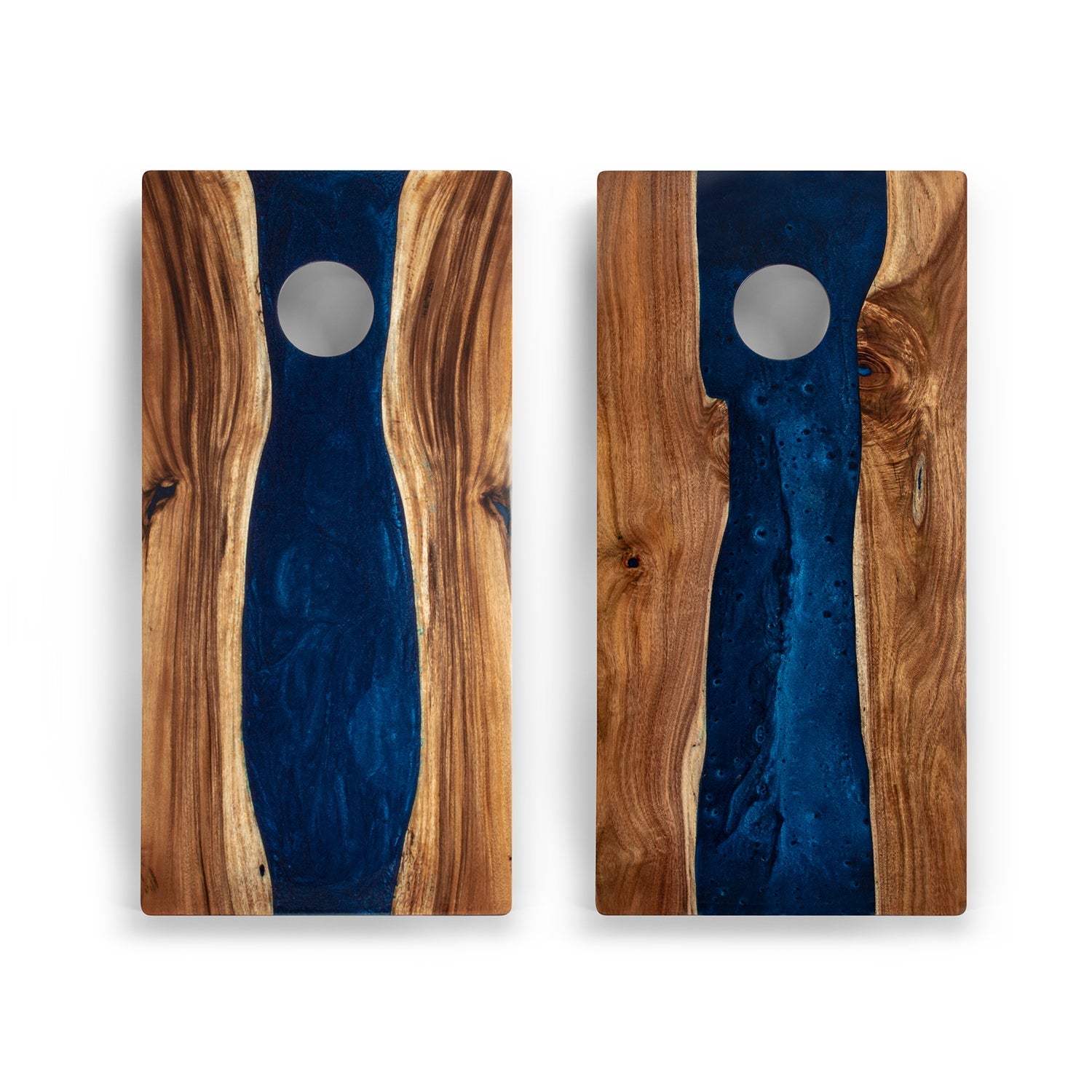 Two wooden cutting boards with blue resin inlay on a white background
