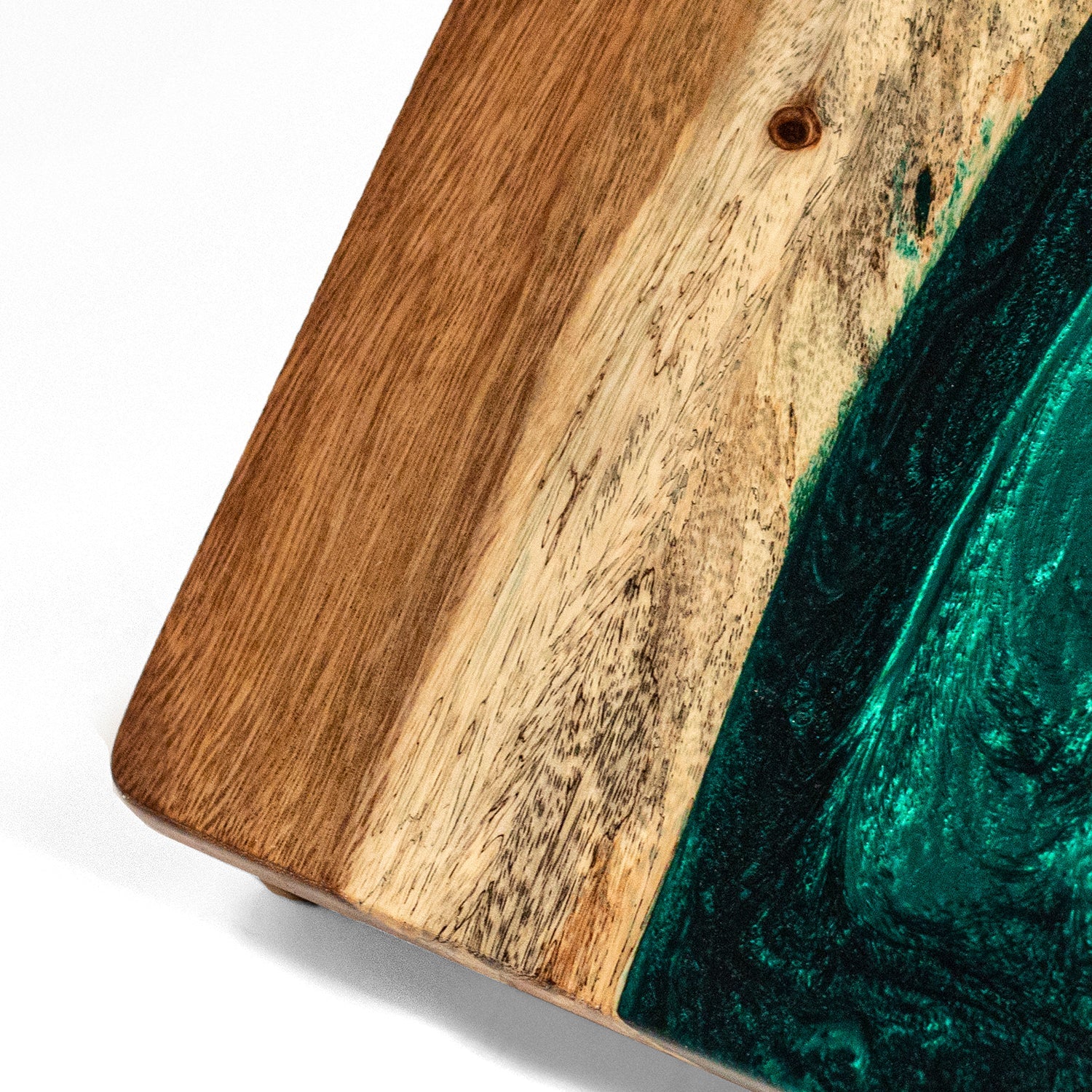 Wooden cutting board with a green resin inlay on a white background