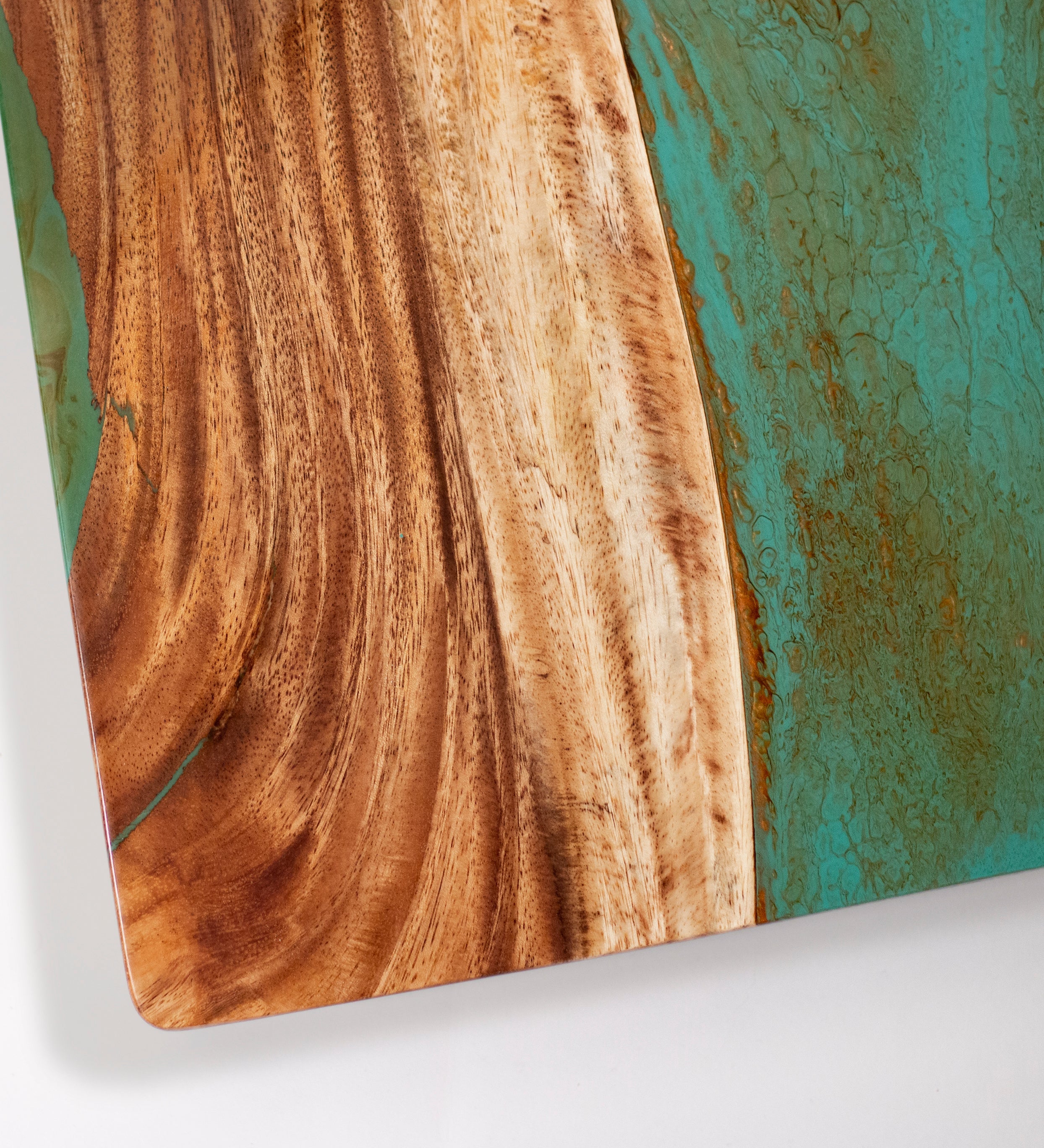 Wooden surface with a turquoise and gold abstract design on a white background