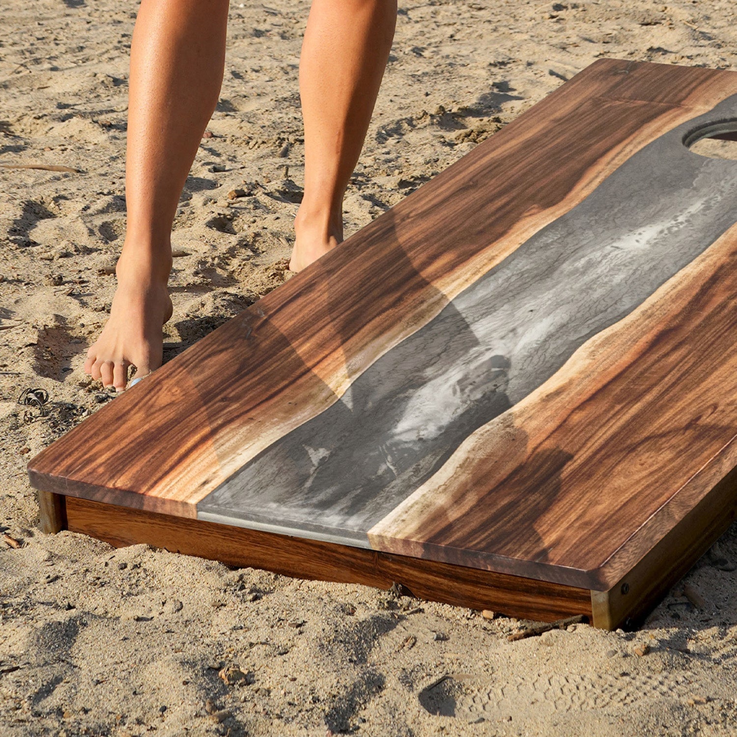 Wooden cutting board with a resin finish on a sandy surface