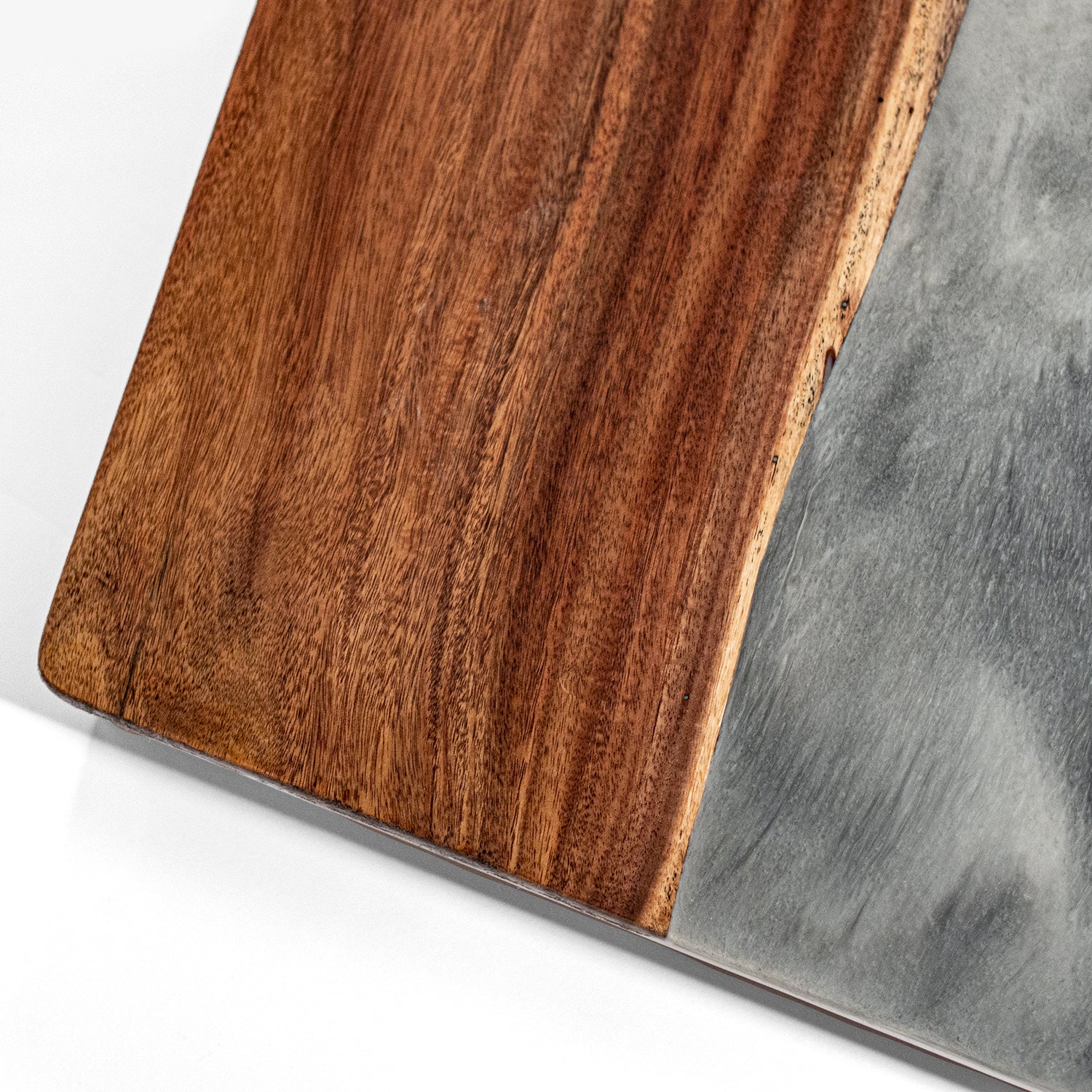 Close-up of a wooden cutting board with a gray stone surface.