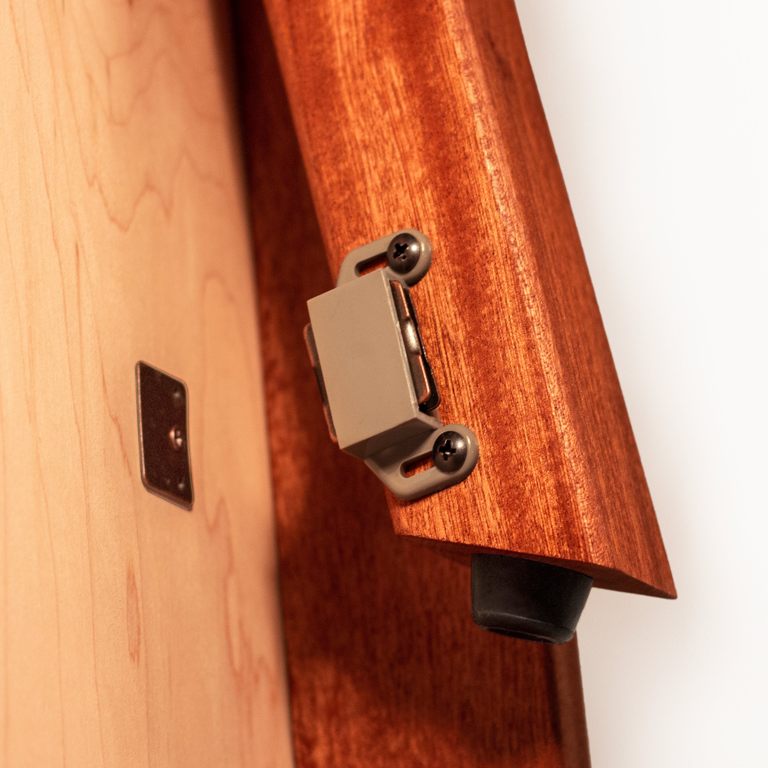 Close-up of a wooden guitar with a metal bridge and white background