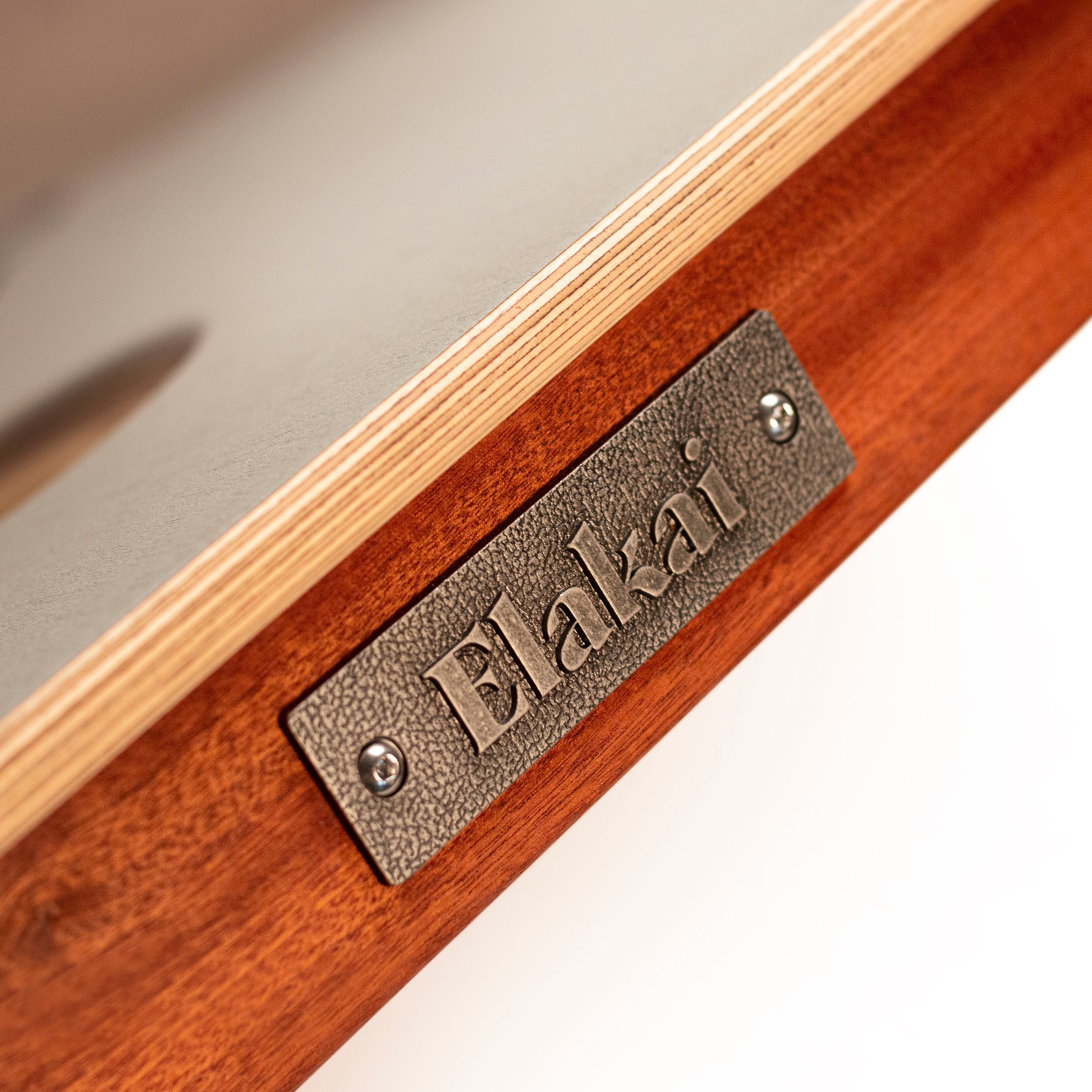 Wooden product with a metal 'Elakat' label on a neutral background