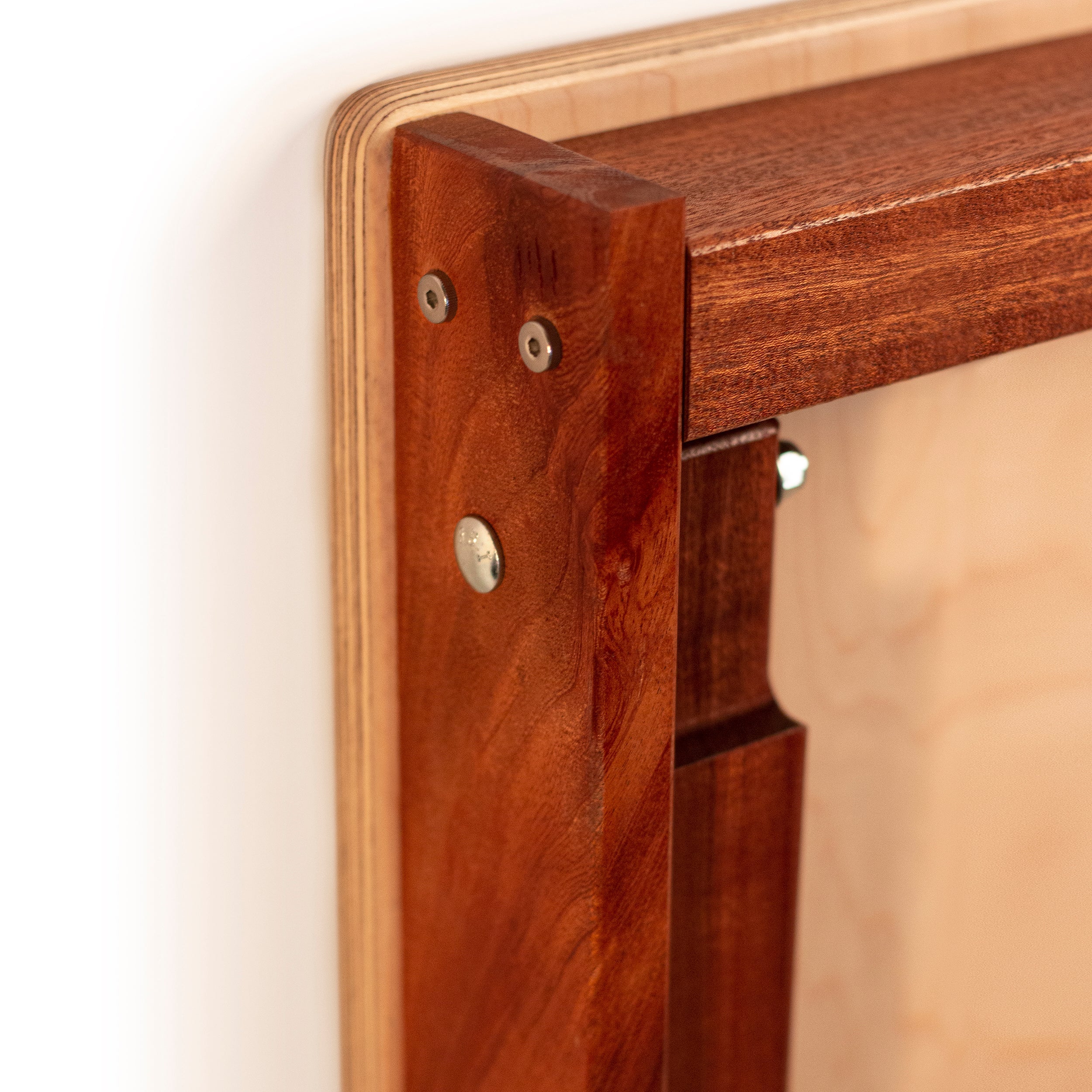 Close-up of a wooden frame with metal fasteners on a white background