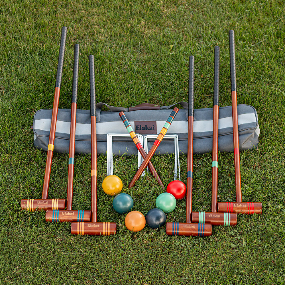 Croquet set with mallets and balls on grass, featuring Elkhart brand.
