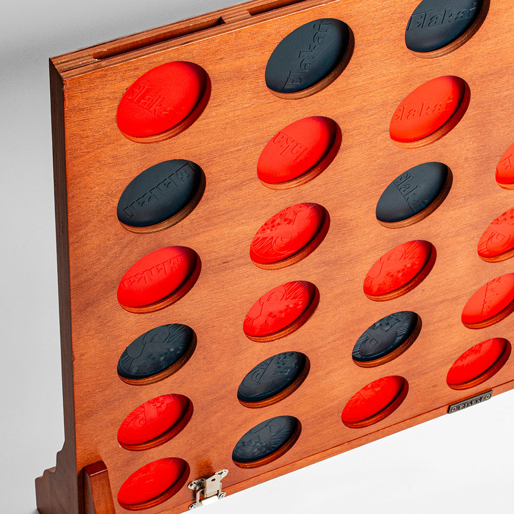 Wooden game board with red and black oval pieces on a gray background
