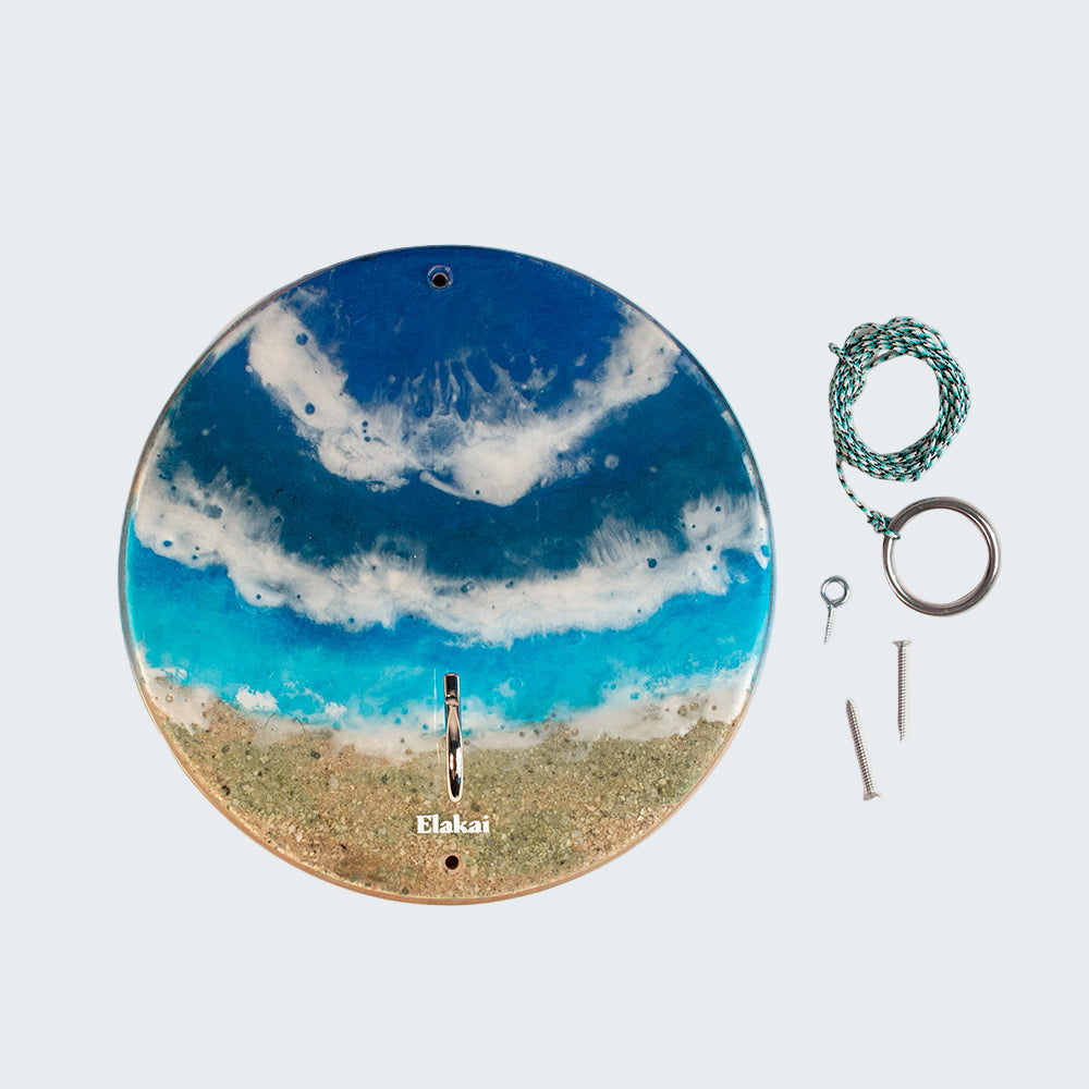 Round decorative piece with blue and white design, accompanied by keys and a rope on a white background.