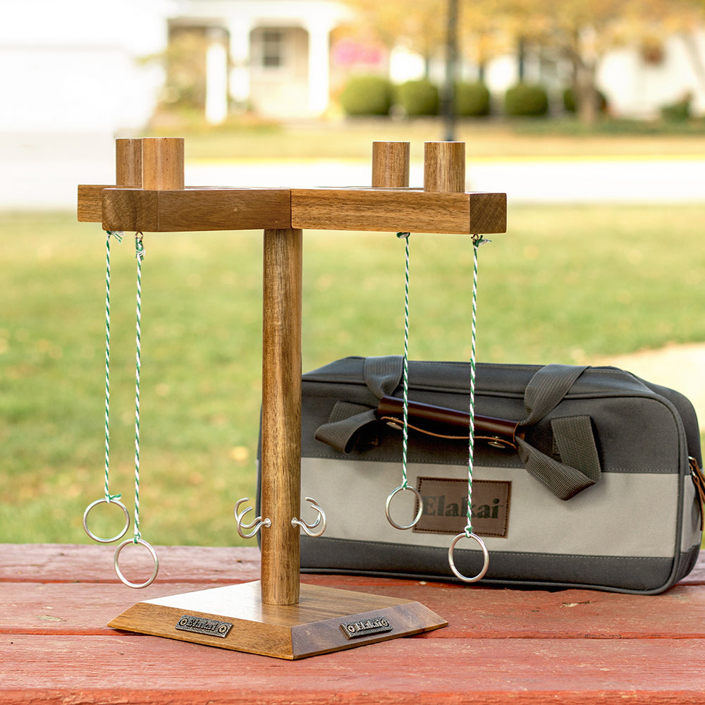 Wooden ring toss game set on a table with a blurred outdoor background