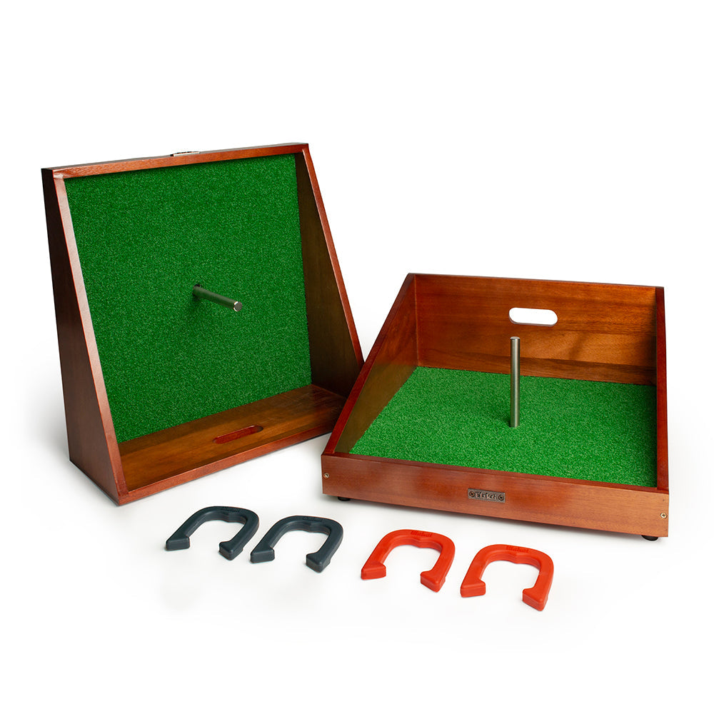 Wooden game board with green felt surface and metal pegs, accompanied by horseshoes on a white background.