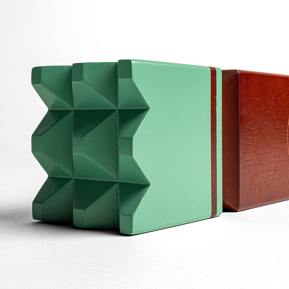 Green and brown geometric-patterned blocks on a white background