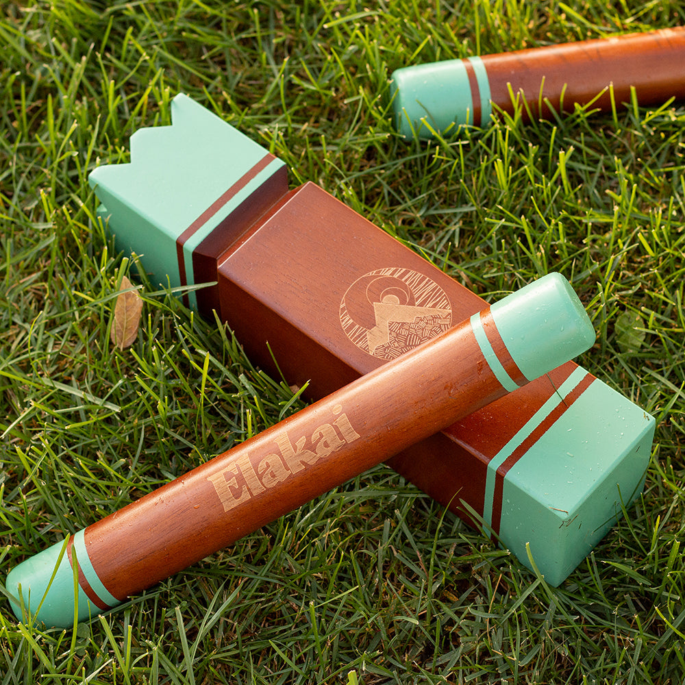 Two wooden croquet mallets with green ends on grass