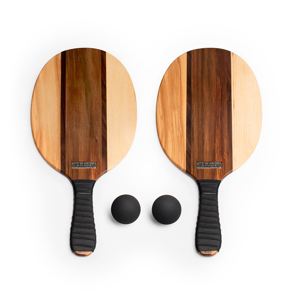 Two wooden pickleball paddles with black handles and two balls on a white background