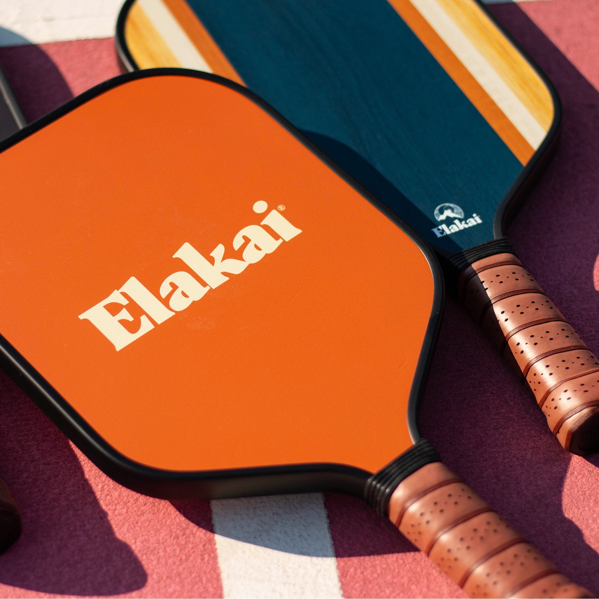 Pickleball paddle with orange face and brown handle on a colorful background