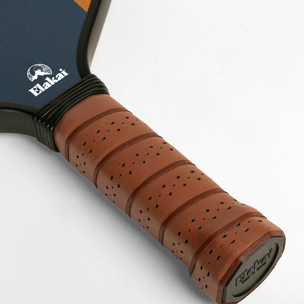 Close-up of a paddle with brown handle and blue paddle face, featuring the Elakai brand.