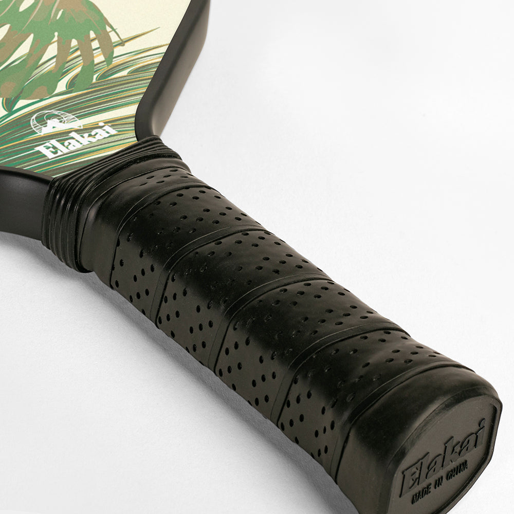 Close-up of a pickleball paddle with a black grip and visible brand name on a white background