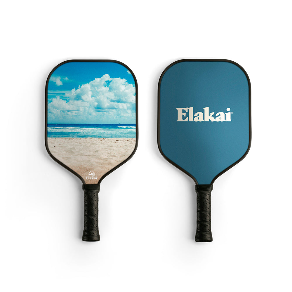 Two pickleball paddles with beach scene and 'Elakai' branding on a white background