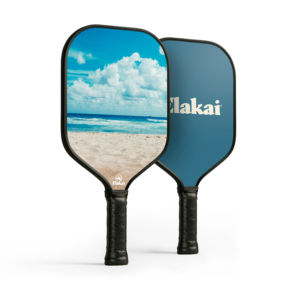 Two pickleball paddles with beach scene design and Elakai branding on a white background