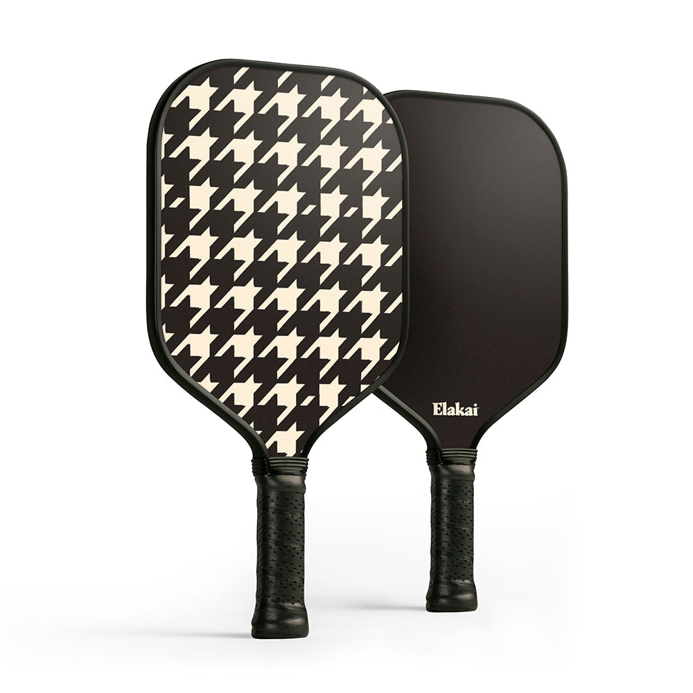 Two pickleball paddles, one with a houndstooth pattern and the other black, on a white background.