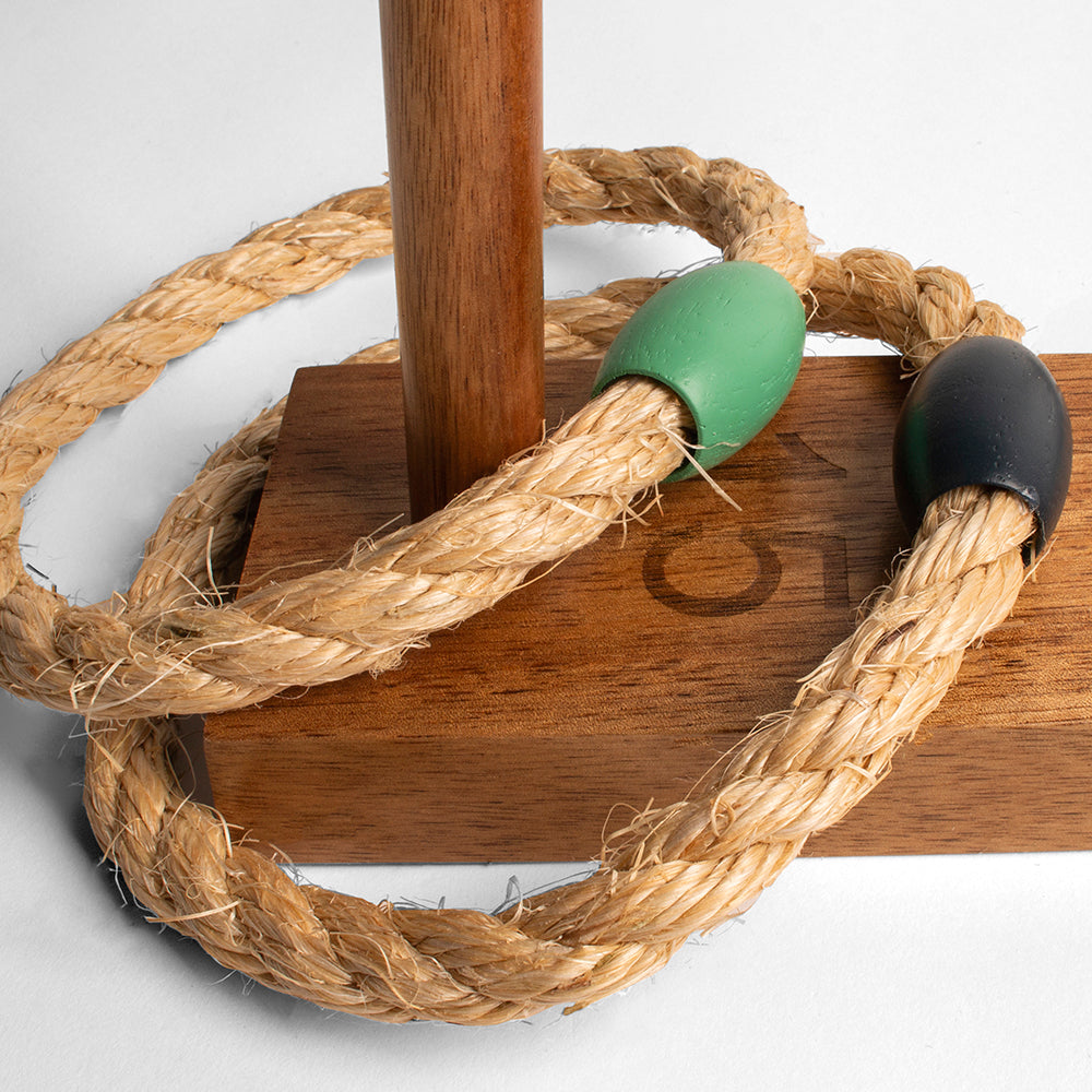 Wooden toy with rope and green and black ends on a white background