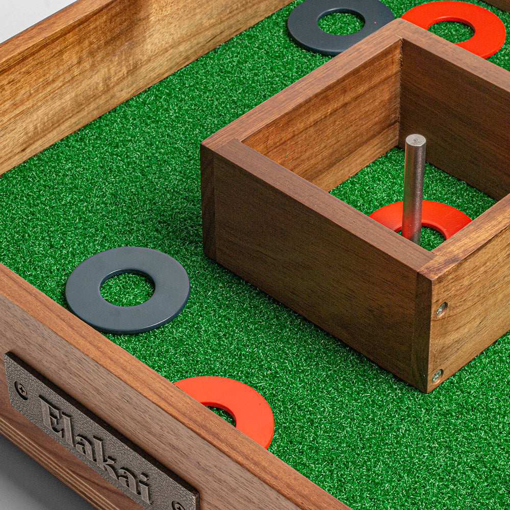 Wooden ring toss game with green playing surface and wooden frame.