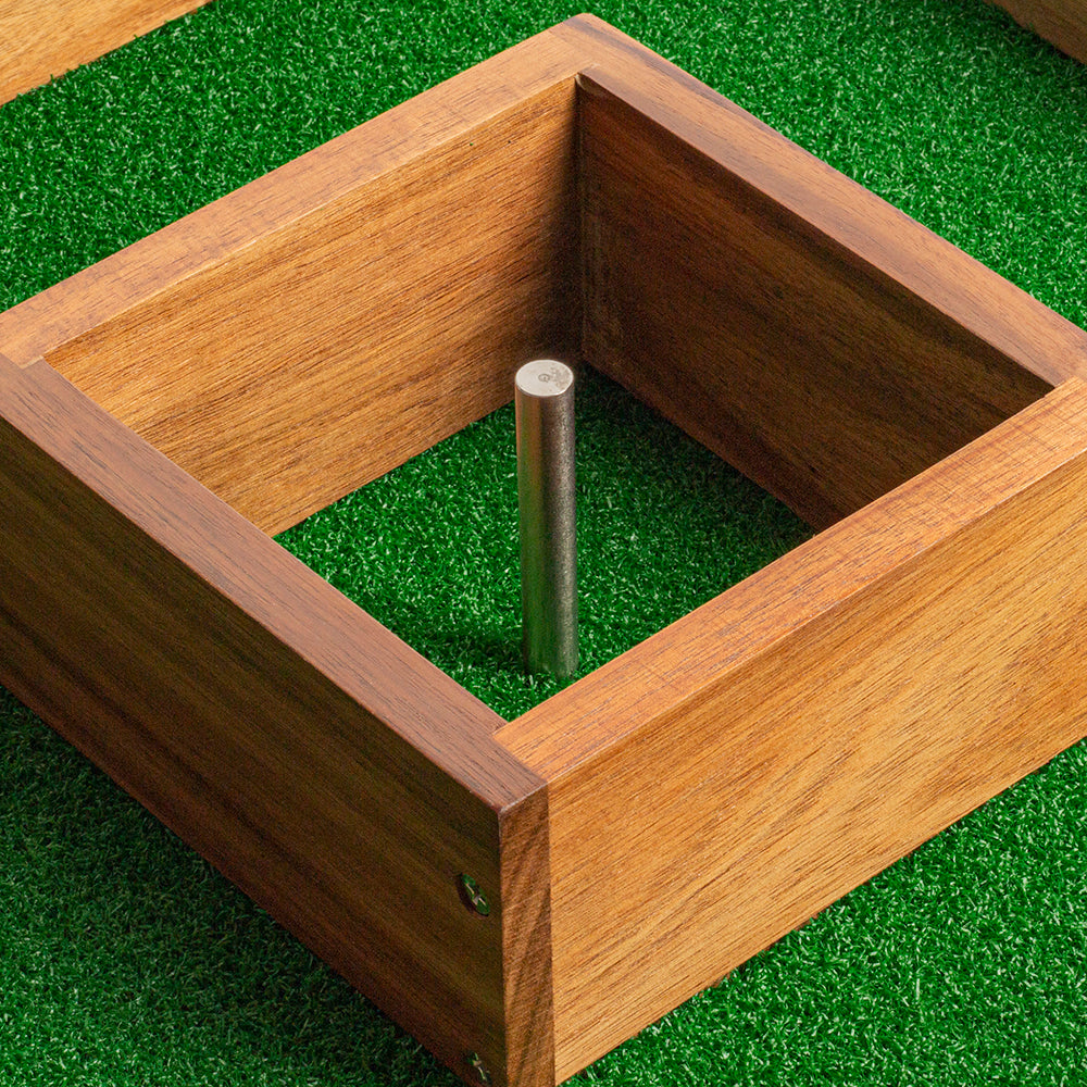 Wooden box with a metal rod on a green grass background