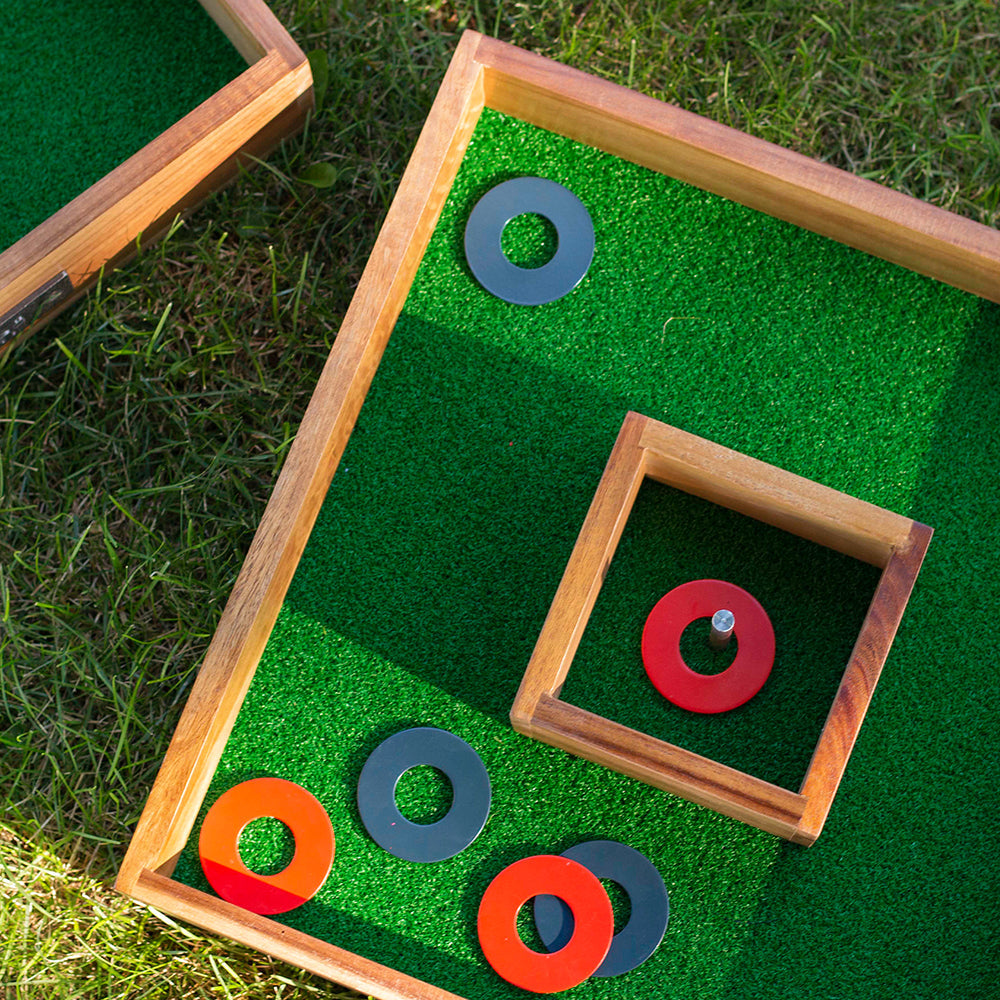 Outdoor game with wooden frames and colored rings on a grassy background