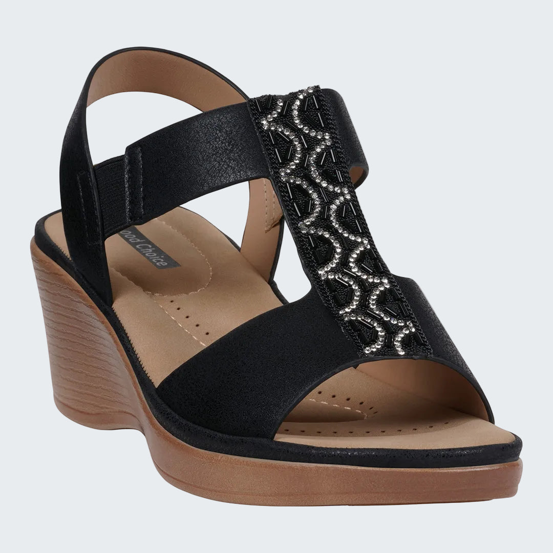 Black wedge sandal with decorative strap on a white background