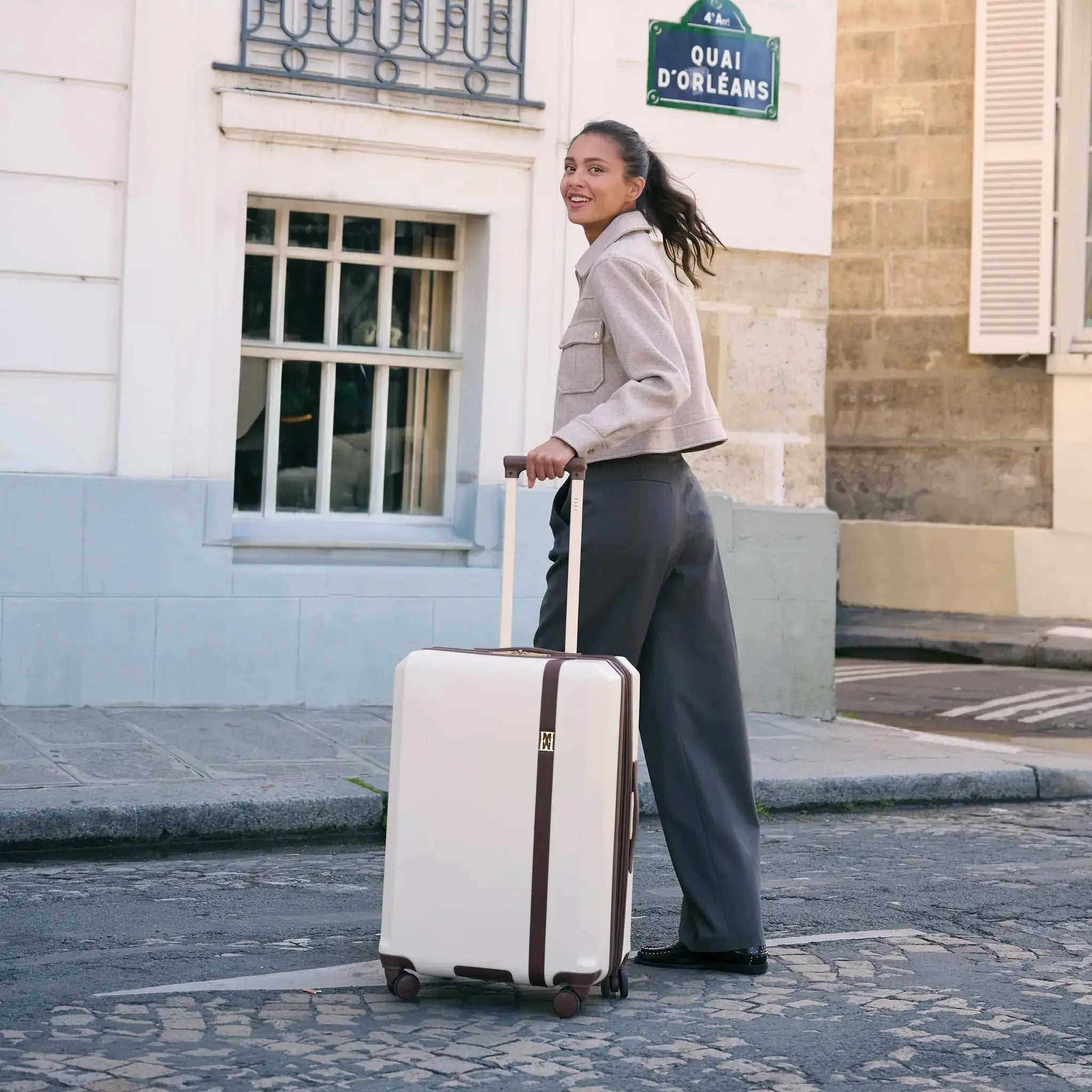 Woman pulling a suitcase on a street in an urban setting