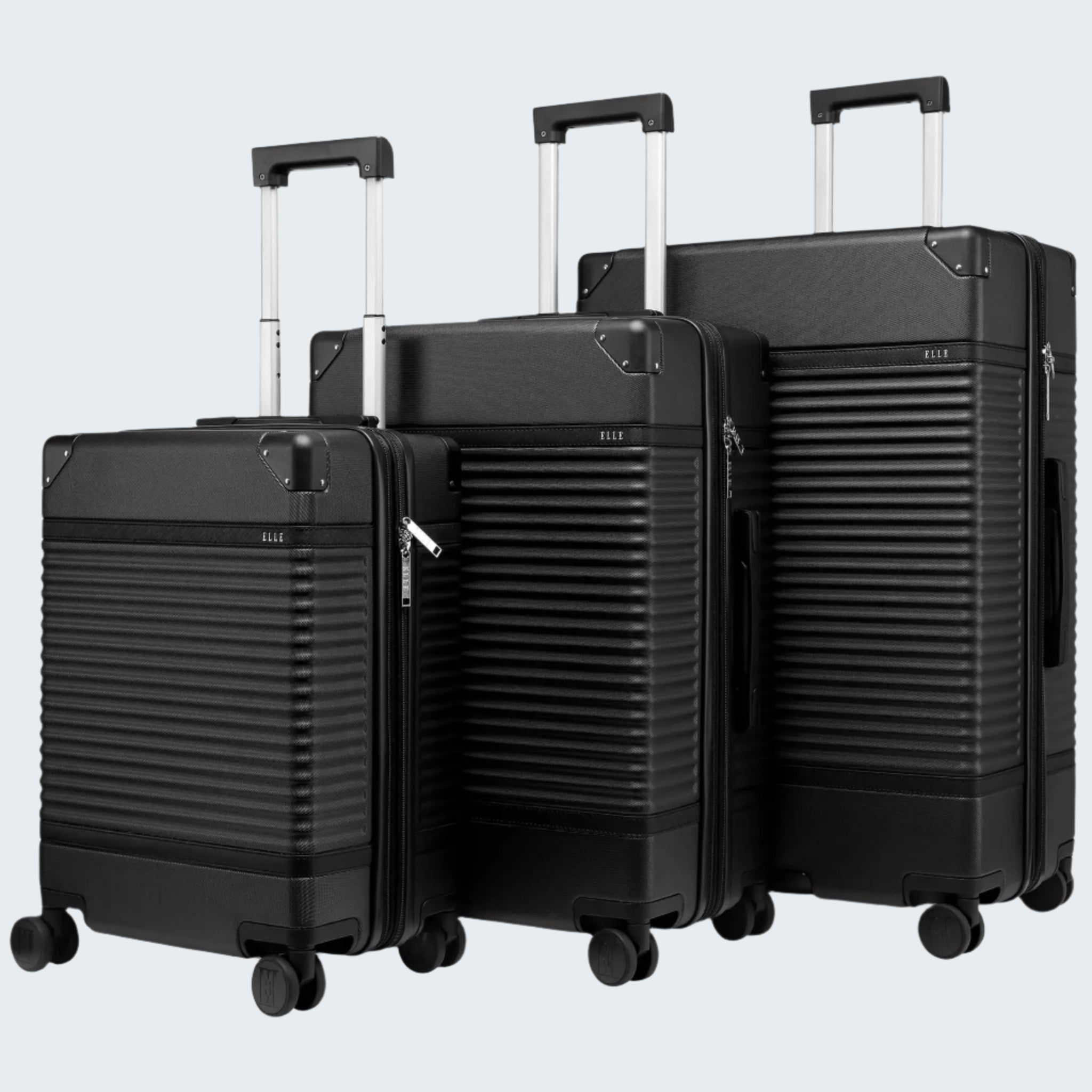 A set of three black colored luggage bags with a hard shell, telescopic handles, and four wheels.
