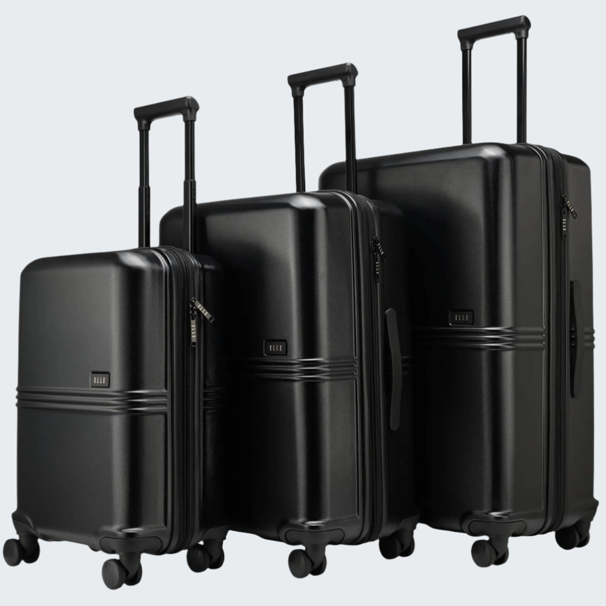 A set of three black polycarbonate suitcases in different sizes, featuring telescopic handles and four wheels.