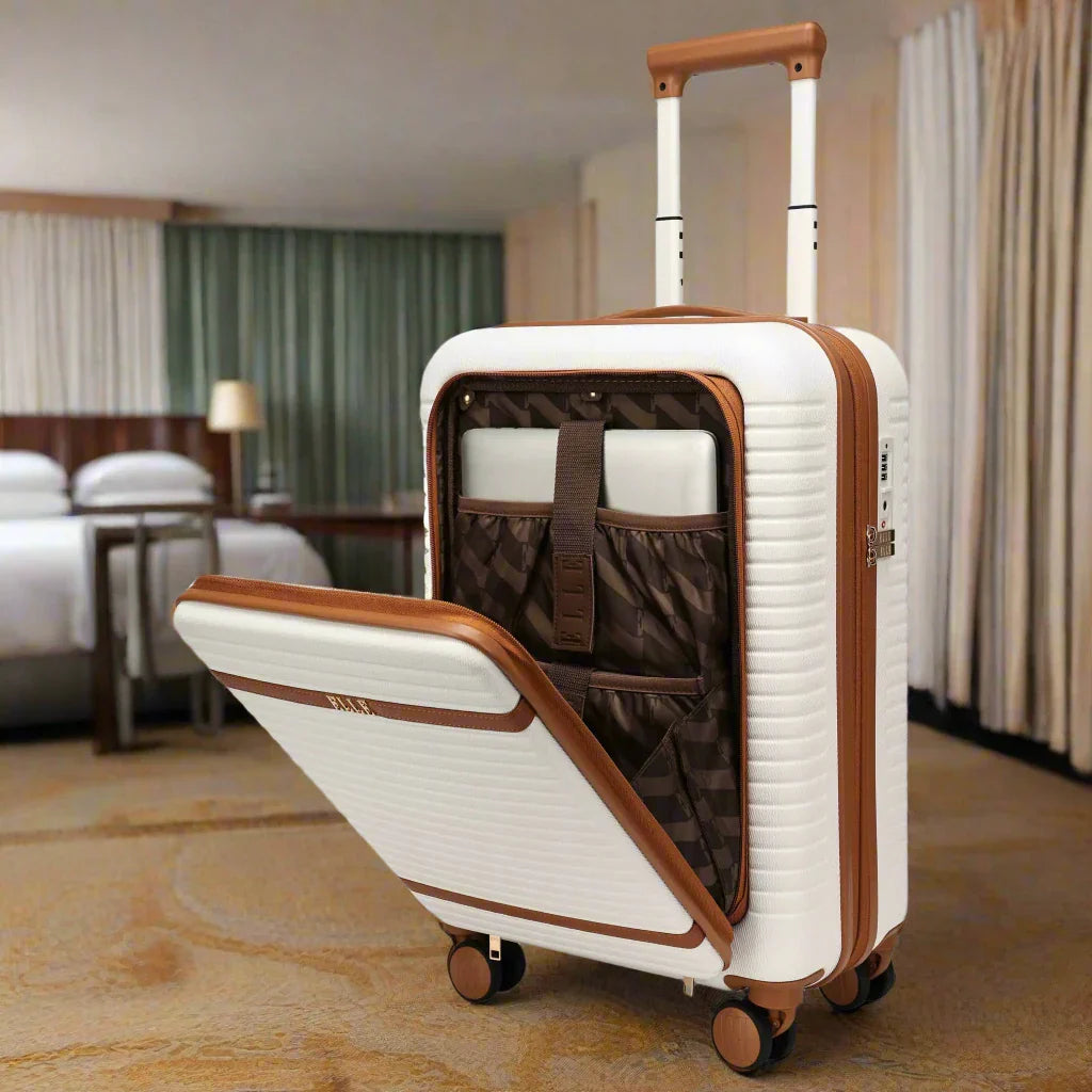 White suitcase with brown accents open in a hotel room