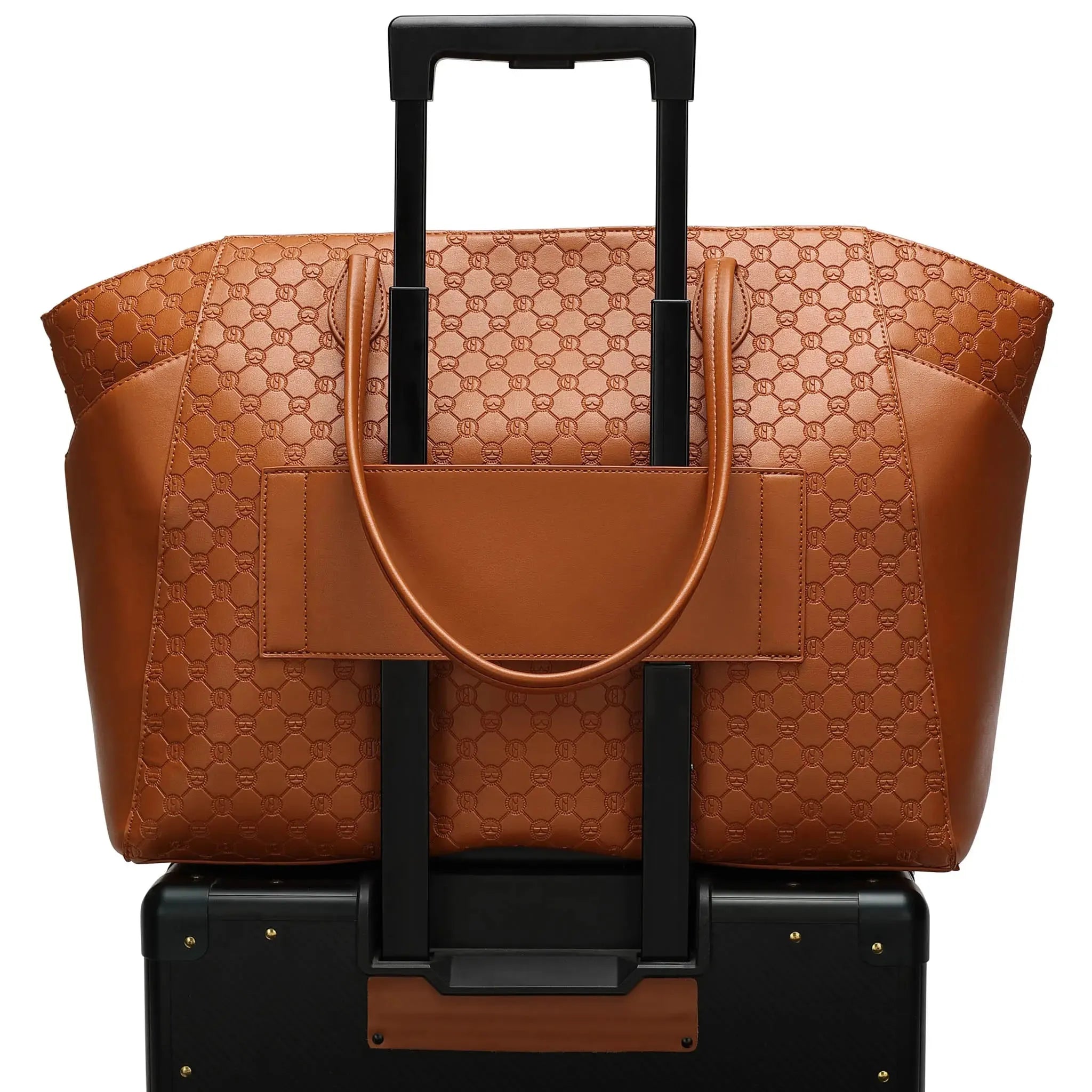 Brown patterned tote bag with black handle on a black suitcase