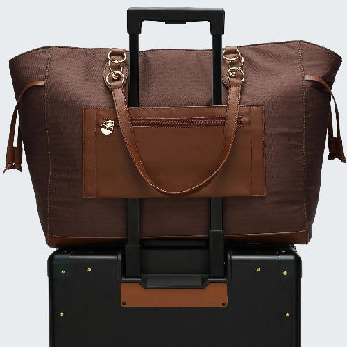 Brown travel bag with a handle and wheels on top of a black suitcase.
