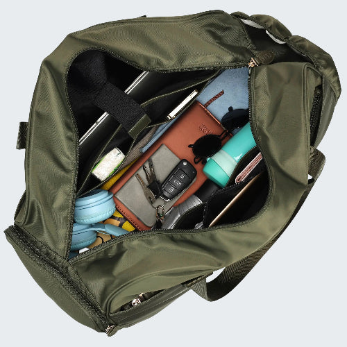 Green duffel bag with various items inside on a white background