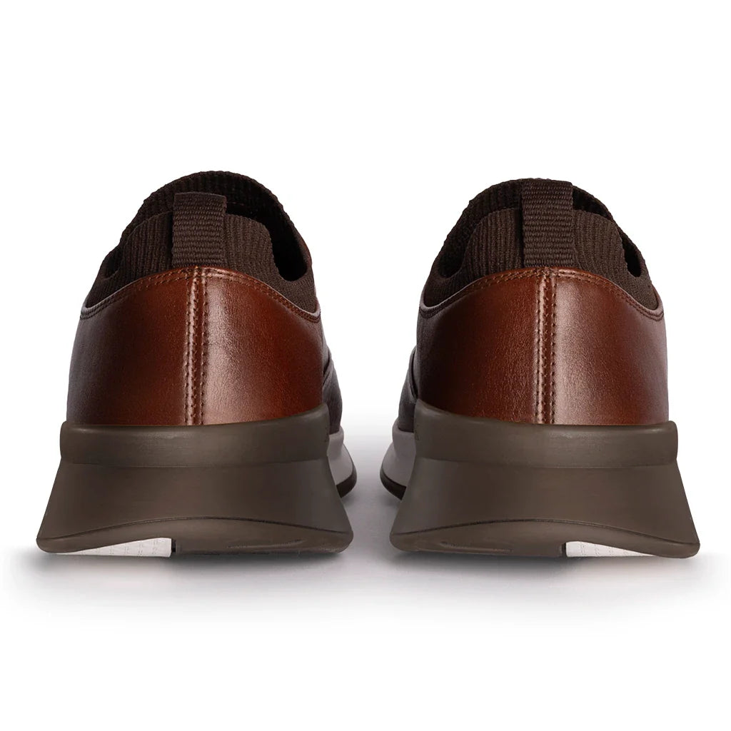 Brown shoes with black soles on a white background