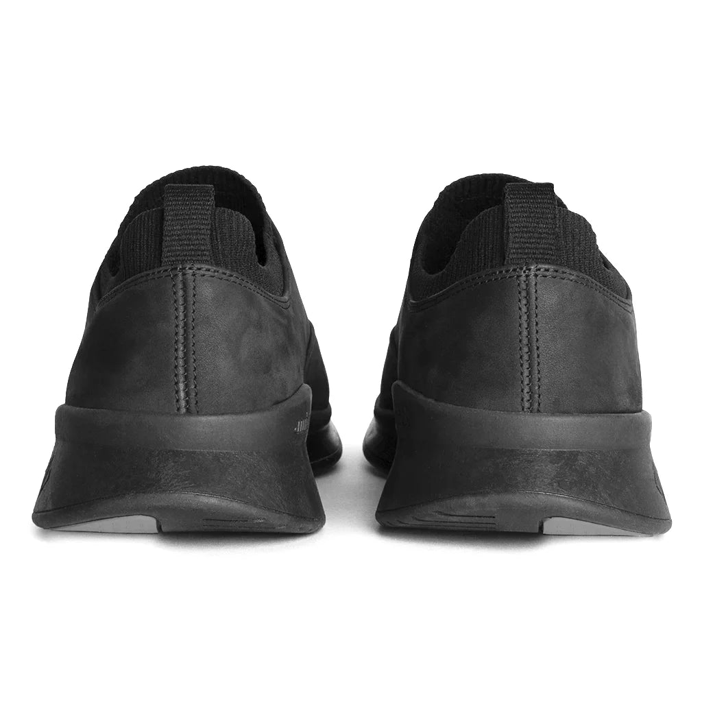 Black slip-on shoes with a thick sole on a white background