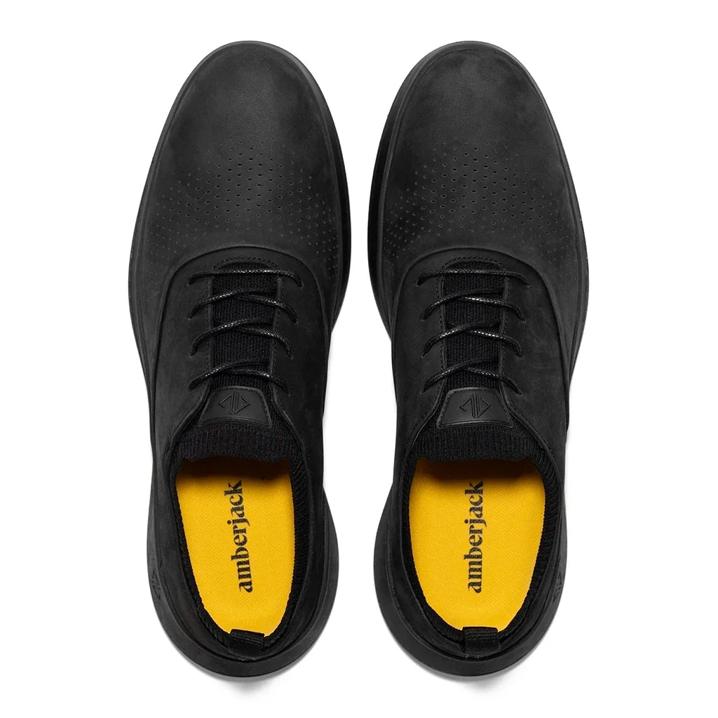 Black shoes with yellow soles on a white background